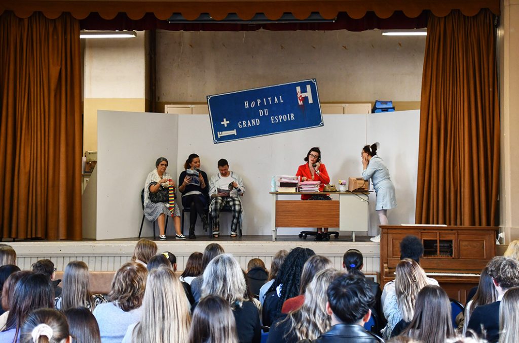 Photographie de la pièce de théâtre sur les mots malheureux, la séquence se passe dans une salle d'attente et l'accueil du service.