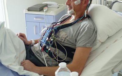 Photo d'un patient équipé du dispositif de polysomnographie et installé dans sa chambre d'hospitalisation